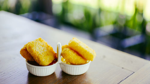 Close-up of fried potatoes in plate containers on table