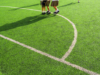 Low section of women standing on soccer field