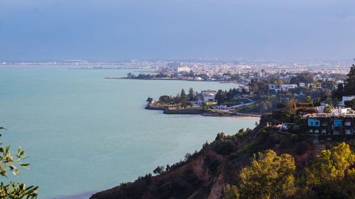 High angle view of buildings and sea against sky