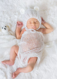 Cute baby girl lying on bed at home