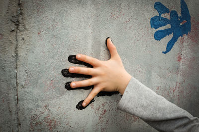 Close-up of hand touching wall