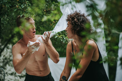 Young man holding woman standing outdoors