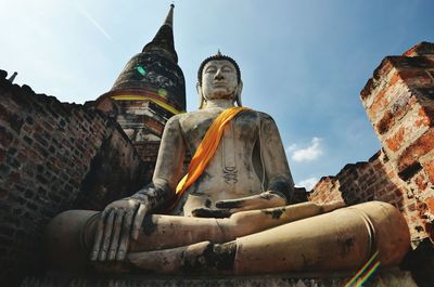 Low angle view of statue against temple building against sky