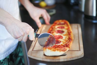 Midsection of man preparing pizza