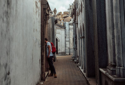 Man standing in alley amidst wall