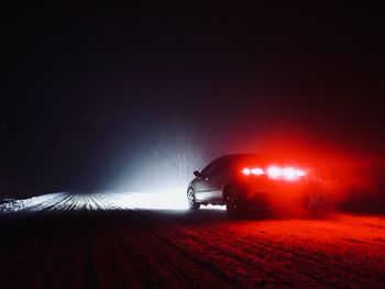 Car on illuminated road at night