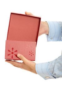 Close-up of hand holding paper over white background