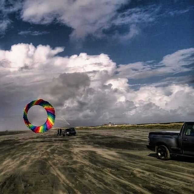 transportation, sky, mode of transport, land vehicle, cloud - sky, car, landscape, hot air balloon, mid-air, cloud, multi colored, flying, field, day, outdoors, cloudy, on the move, no people, travel, adventure
