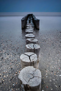 Wooden posts on shore at beach