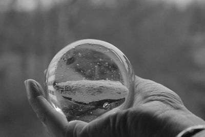 Close-up of hand holding crystal glass