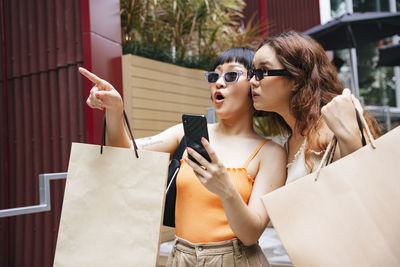 Young woman holding sunglasses