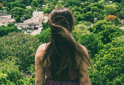 Rear view of woman standing against trees