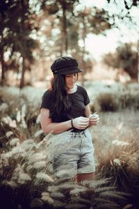 Young woman wearing hat while standing on land