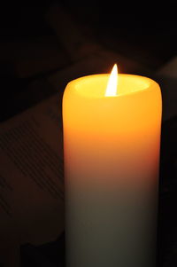 Close-up of illuminated candle in darkroom