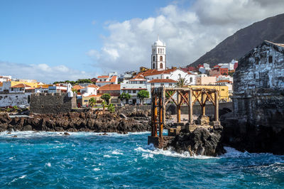 City at waterfront against cloudy sky - garachico, tenerife