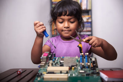 Little girl playing with motherboard computer at home