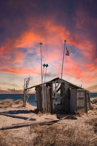 Pink sunrise sky over the occupy chatham public shack on chatham south beach on cape cod.
