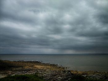 Scenic view of sea against storm clouds