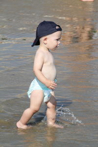 Full length of shirtless boy in water