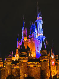 Low angle view of illuminated buildings against sky at night