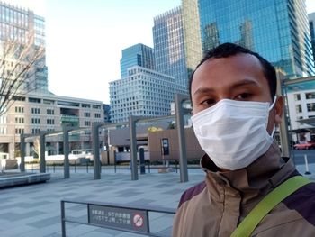 Portrait of man against buildings in city