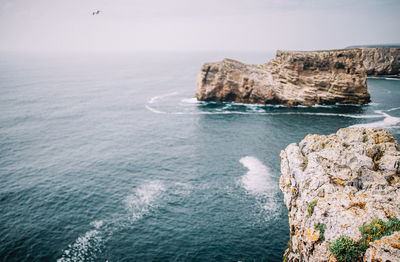 Rock formation in sea against sky