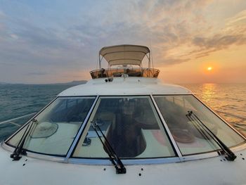 Ship sailing on sea against sky during sunset