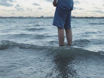 Midsection of woman standing in sea