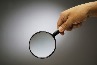 Close-up of hand holding glass against white background