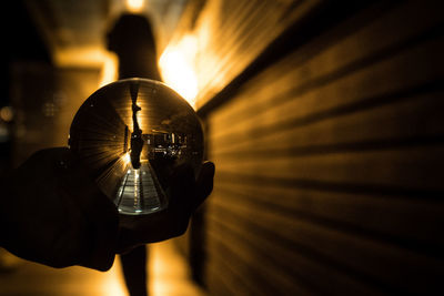 Close-up of hand holding illuminated lamp