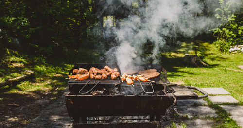 Meat on barbecue grill in in yard