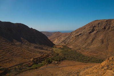 Scenic view of mountains against clear blue sky