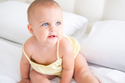 Portrait of cute baby boy lying on bed at home