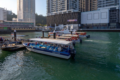 Boats in canal by buildings in city