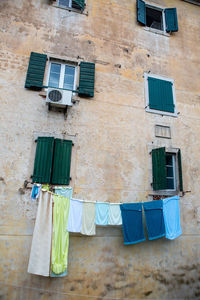 Multi-colored linen is dried outside the window of an old house in montenegro
