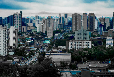 View of cityscape against cloudy sky