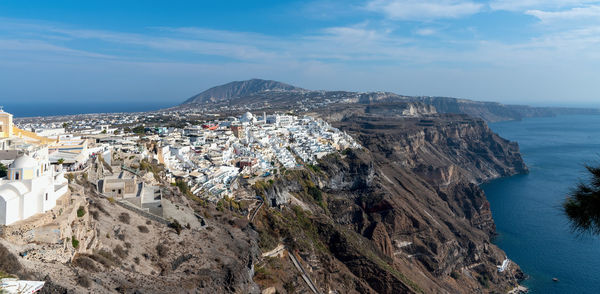 Aerial view of townscape by sea against sky