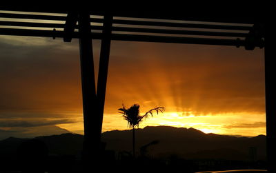 Silhouette palm trees against sky during sunset