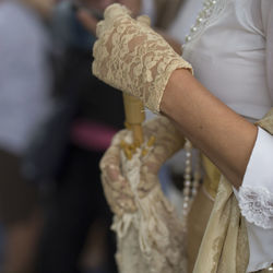 Midsection of woman holding cross against blurred background