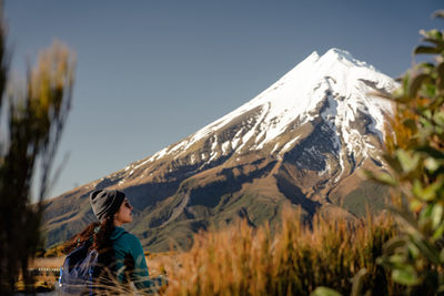 Woman on snowcapped mountain against sky