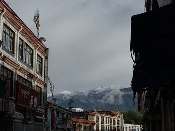 Low angle view of buildings against cloudy sky