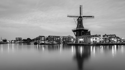 River with windmill against the sky