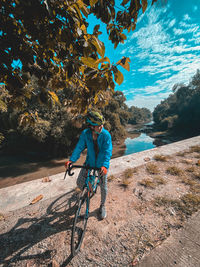 Rear view of man riding bicycle in water