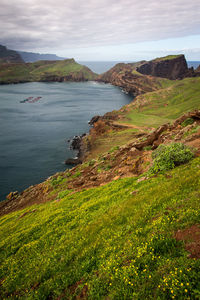 Scenic view of mountains and sea against cloudy sky