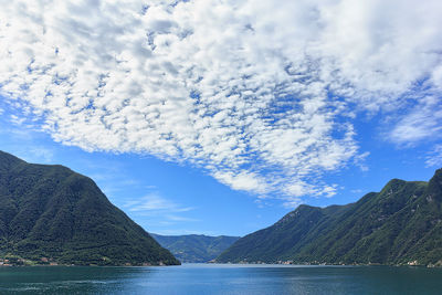 Scenic view of sea and mountains against sky