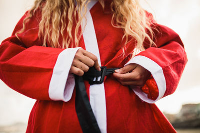 Midsection of woman wearing santa costume