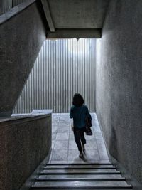 Rear view of woman walking on staircase