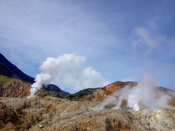 Smoke emitting from volcanic mountain against sky