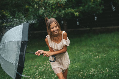 Portrait of smiling young woman standing on field