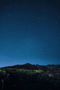 Scenic view of landscape against star field at night